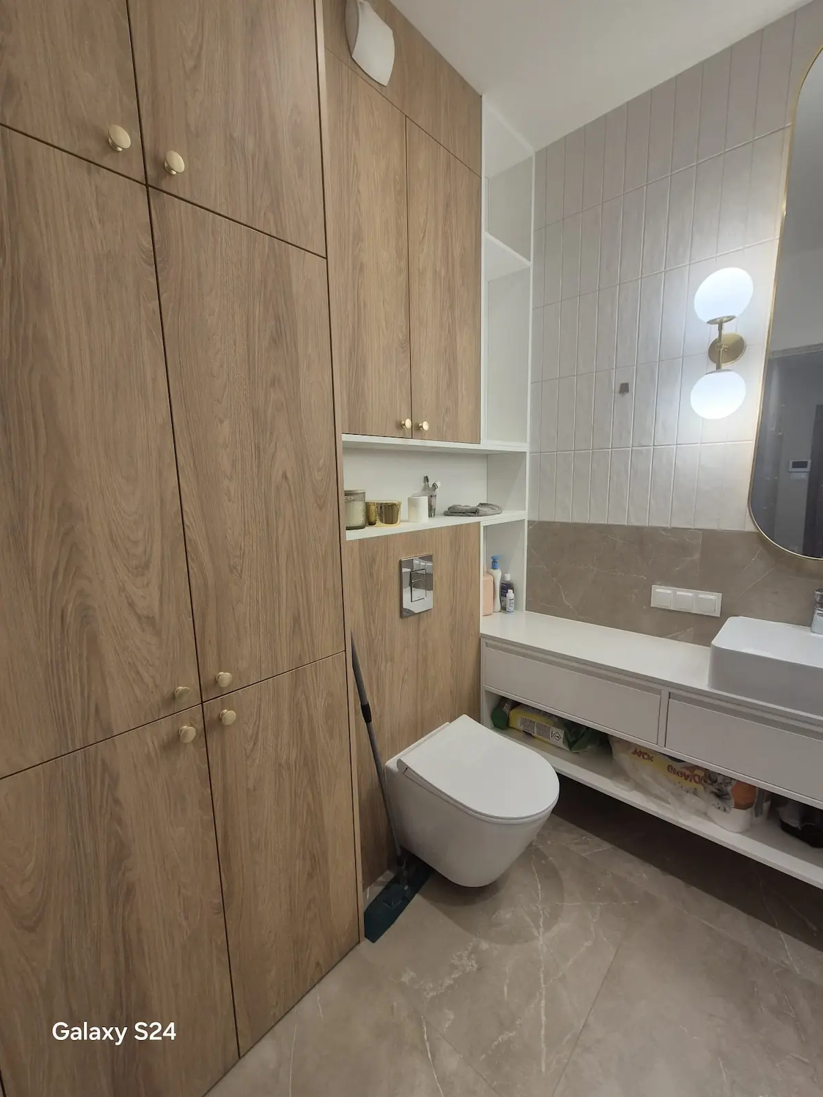 Nowoczesna łazienka premium z zabudową meblową w drewnie, podwieszaną toaletą i elegancką strefą umywalki – wykończenie wnętrz DECO MAX Rzeszów