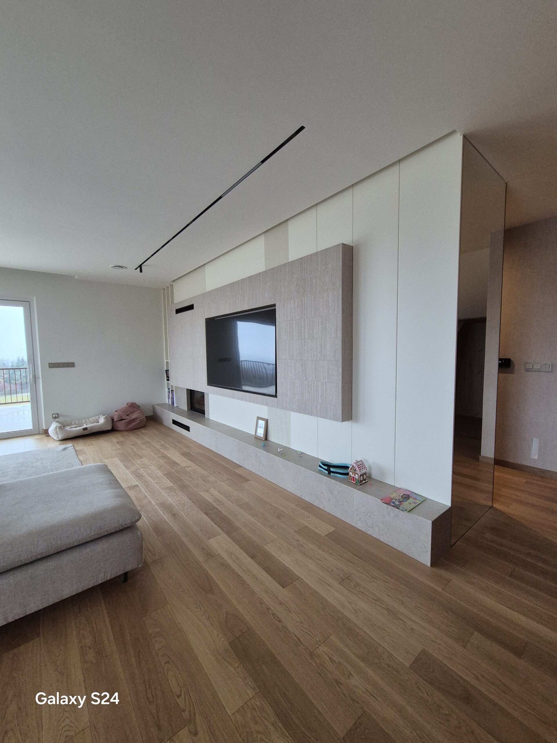 Nowoczesny salon z zabudową RTV na wymiar, drewnianą podłogą i minimalistycznym designem – wykończenie wnętrz DECO MAX Rzeszów